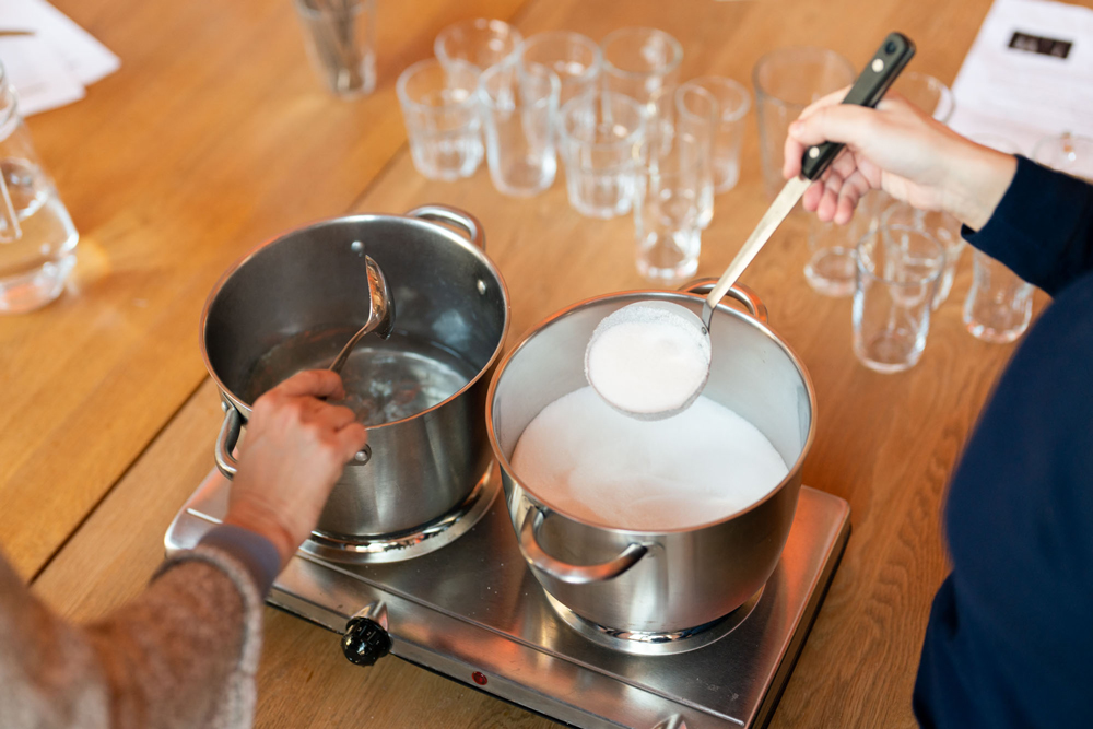 Sugar being added to pans of boiling water